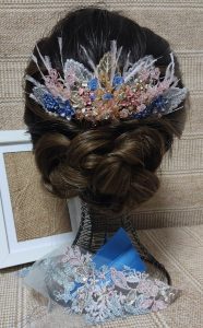 Tocado personalizado con tonos del vestido, utilizando la propia tela y otros detalles externos.