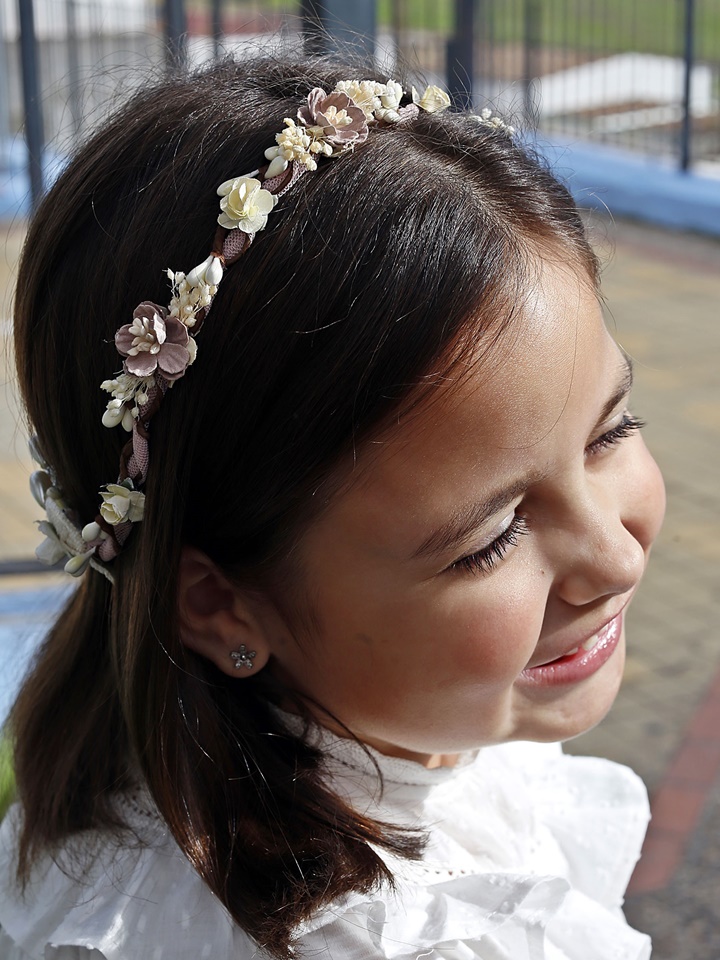 Corona de comunión modelo Mérida, de color rosa y adornada con perlas blancas brillantes, perfecta para un look elegante en el día de la comunión.