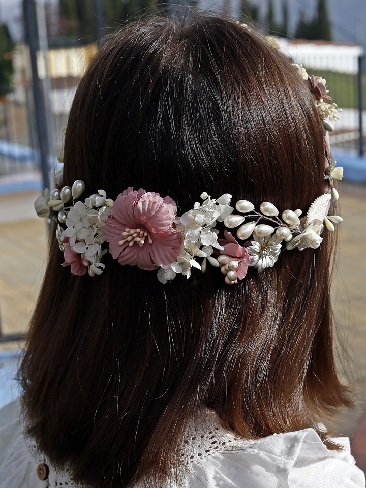 Corona de comunión modelo Mérida, de color rosa y adornada con perlas blancas brillantes, perfecta para un look elegante en el día de la comunión.